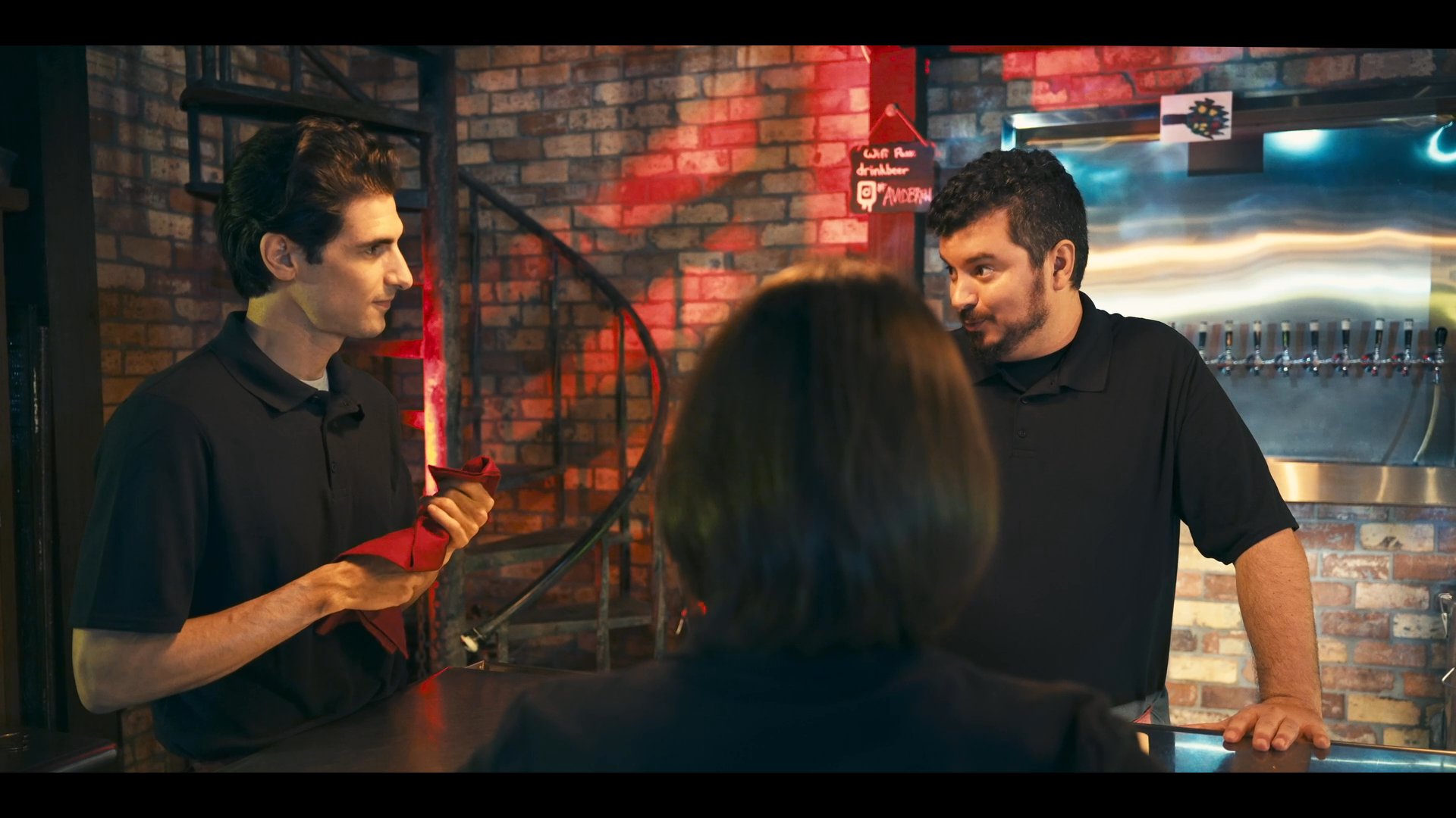 Two bartenders engage in a service demonstration in a professional bar setting, followed by two men discussing business at a table.