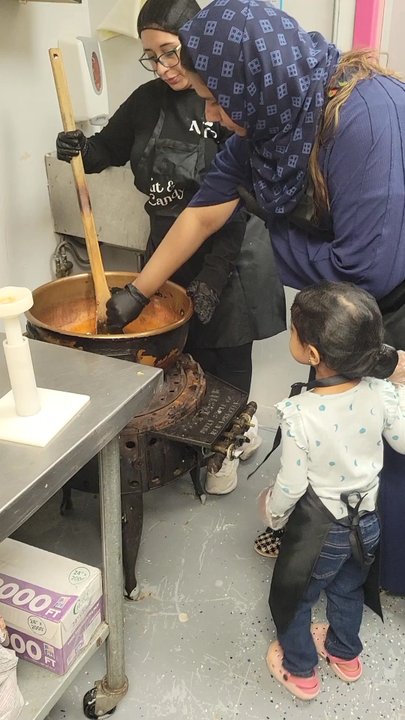 NC Chocolatier - Dipping the apple into the caramel - Candy Stores Near Me - Skokie, Illinois