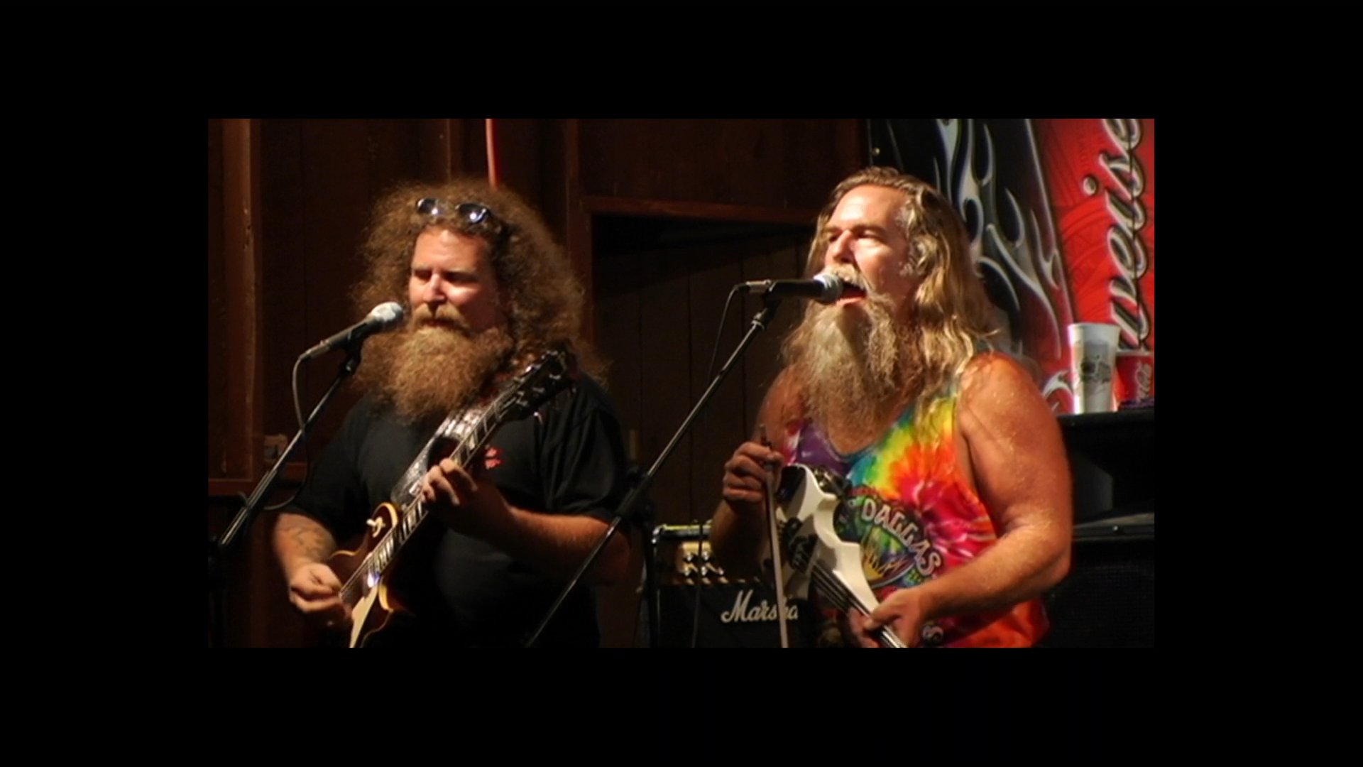 A memorial sequence honors Mark Fryed and the fallen members of The Fryed Brothers Band, featuring archival concert footage and professional credits.