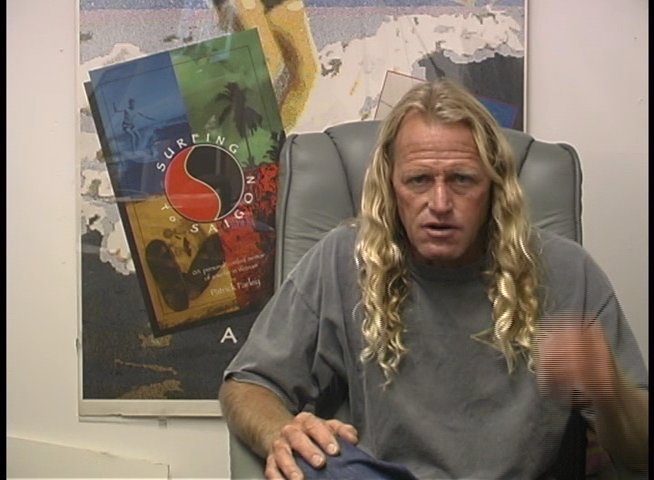 A blonde man with curly hair speaks directly to the camera during an interview session in an office setting.