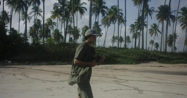 A photographer walking on a beach