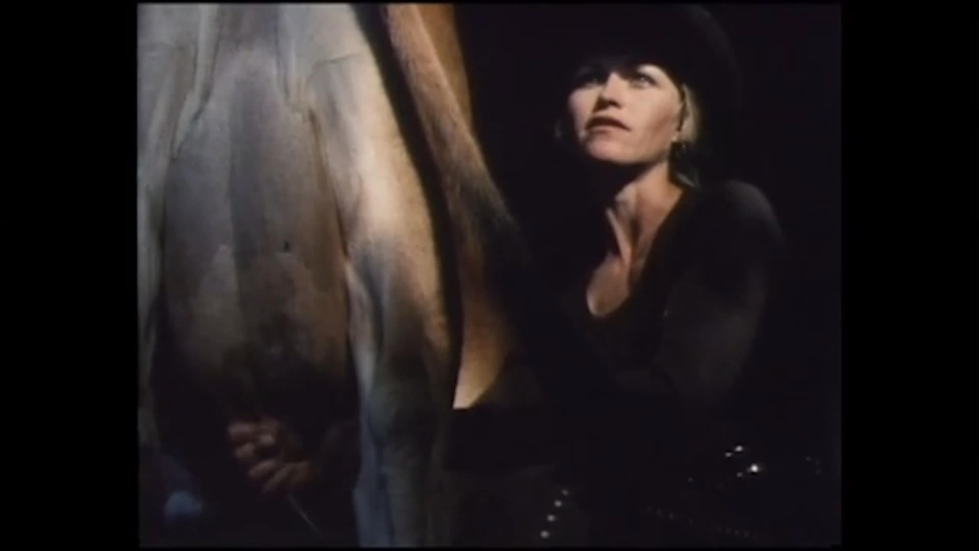 A woman stands close beside a horse as she reflects on a relationship built around mutual respect and independence. The scene shifts to a rodeo arena, where a rider competes on a bucking horse before a crowd.