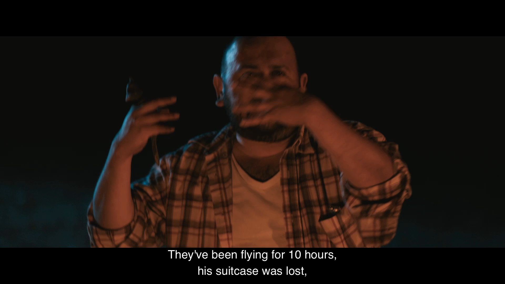 A man recounts an exasperated story about a traveler requesting bread while sitting near a fire at night. His companion listens as he describes the absurdity of the interaction.