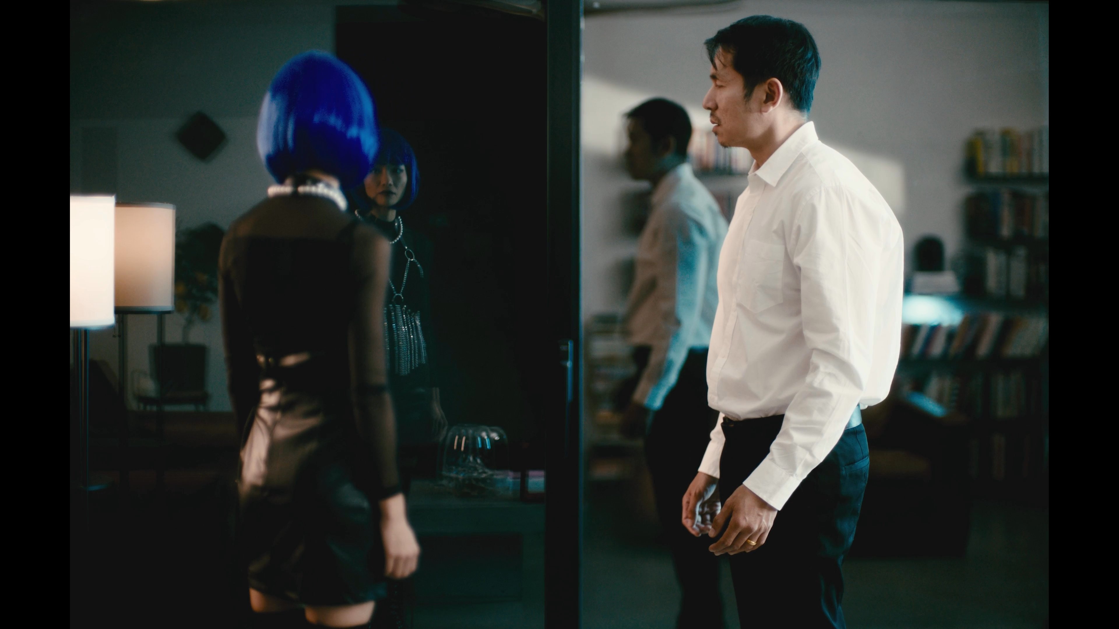 A man and woman experience a tense encounter inside a modern residence before the man departs the premises. The interaction emphasizes emotional distance within a sophisticated living environment.