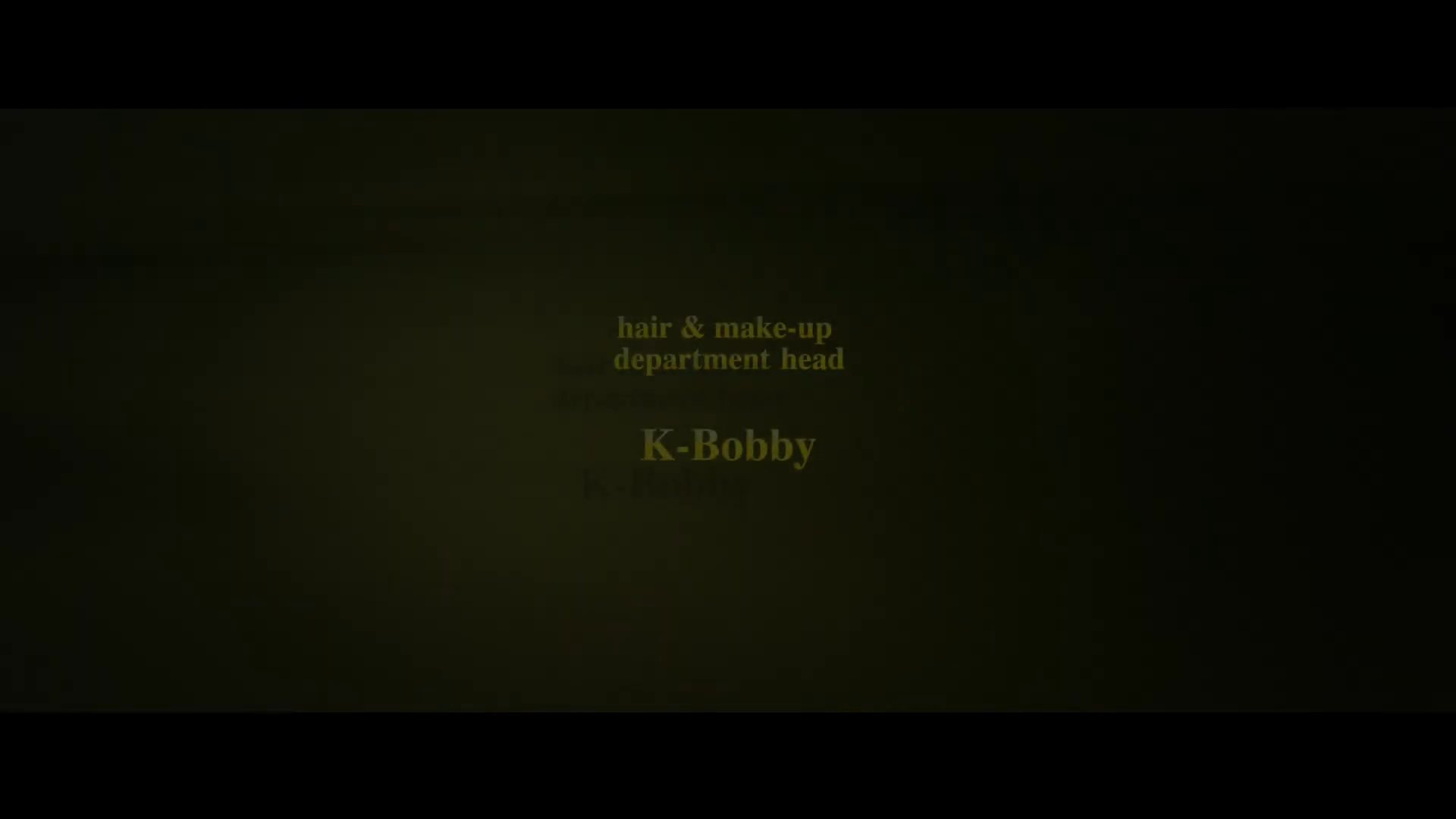 Text overlays display the cast and production crew names against a dark, minimalist background. The sequence systematically reveals individual roles and contributors involved in the film's creation.