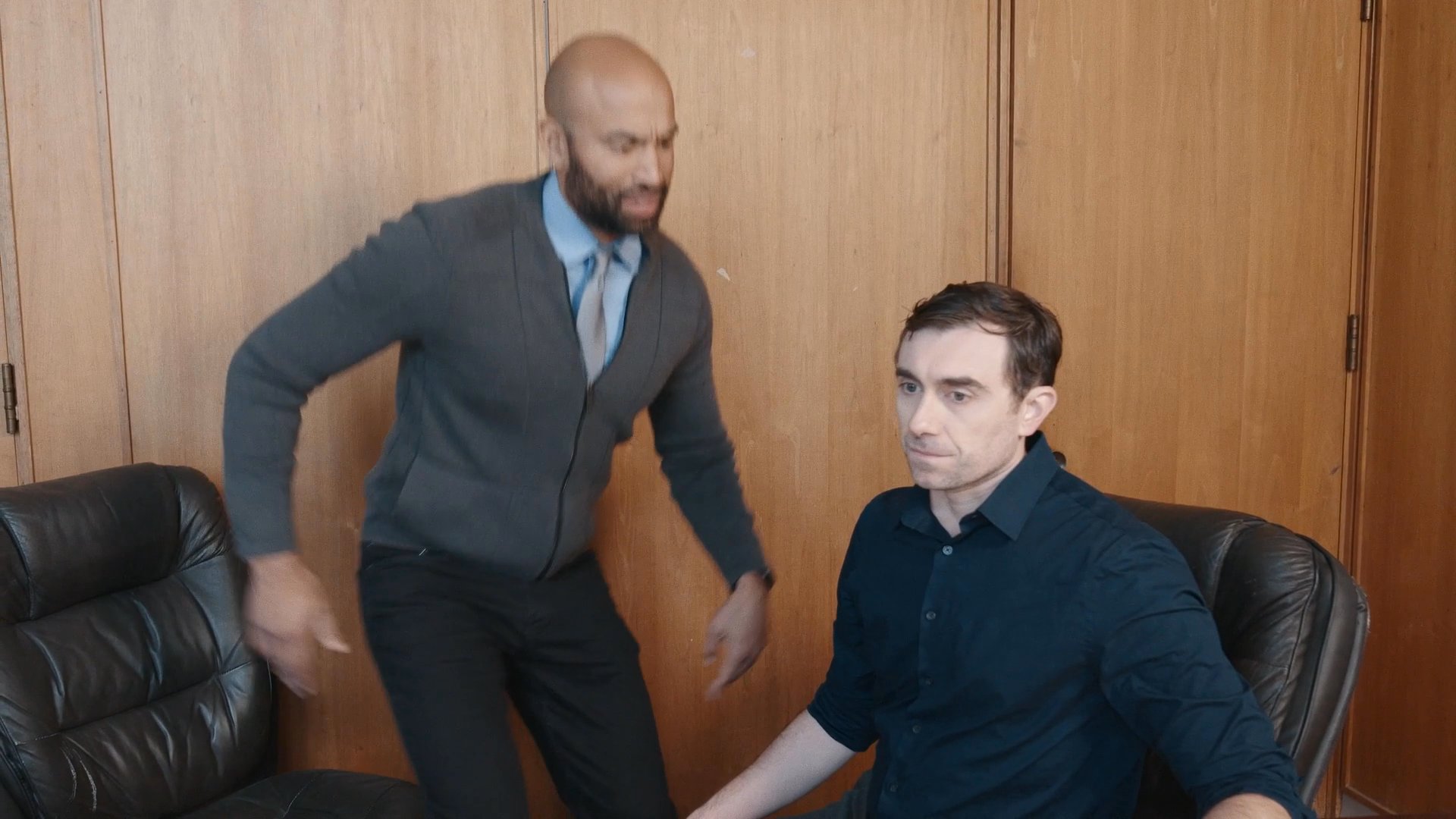 A mentor guides a colleague into a conference room, illustrating the transition from professional collaboration to the personal impact of persistent work-related stress during late-night hours.
