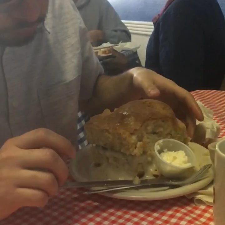 Jackie's Ham 'n Eggs - Trying to take a bite out of the gigantic Biscuit - N - Gravy that came with his meal! - Breakfast & Brunch Near Me - Lewisville, Texas