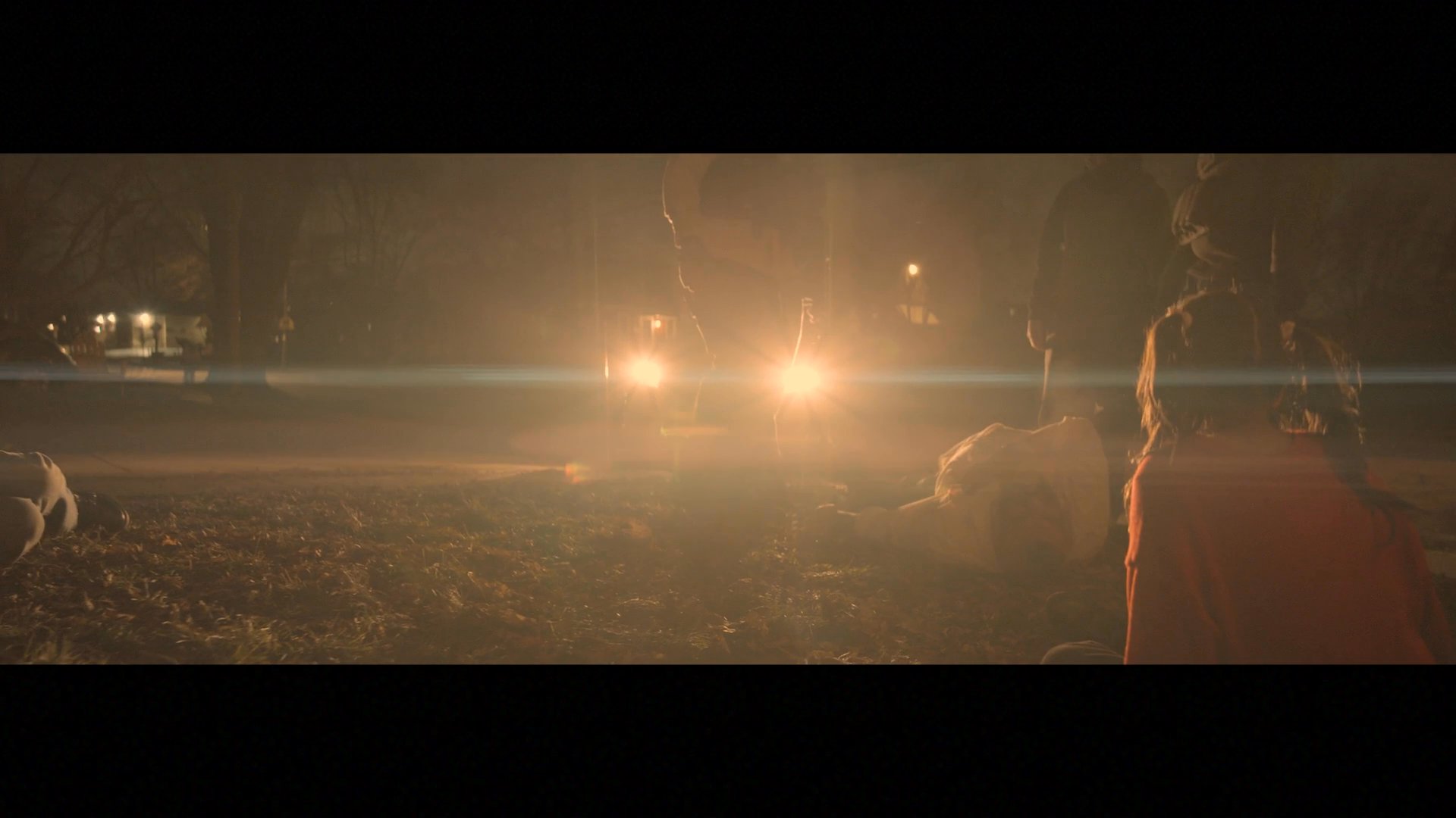 Tactical units detain a suspect in a suburban residential area at night while family members look on in distress. The emotional toll on the observers is emphasized through intimate close-up reactions.