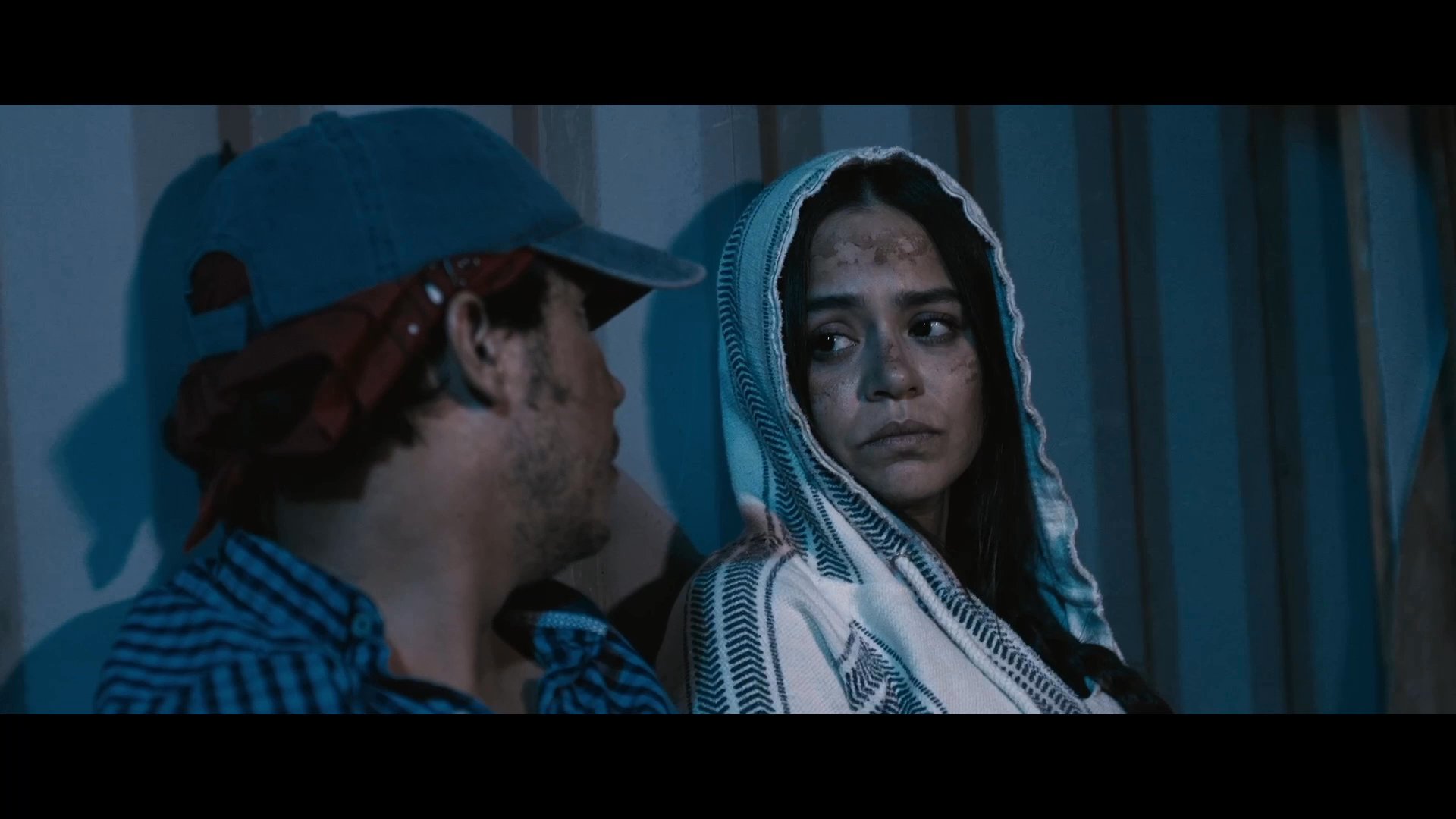 A man and a woman engage in an intense, emotionally charged discussion regarding their sacrifices and the fairness of their situation. The somber atmosphere underscores the weight of their ongoing personal conflict.