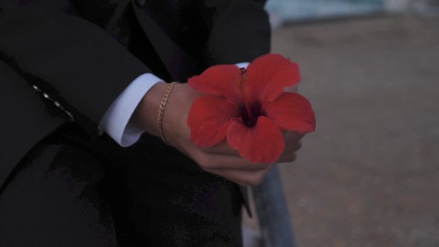 Man holding a red flower