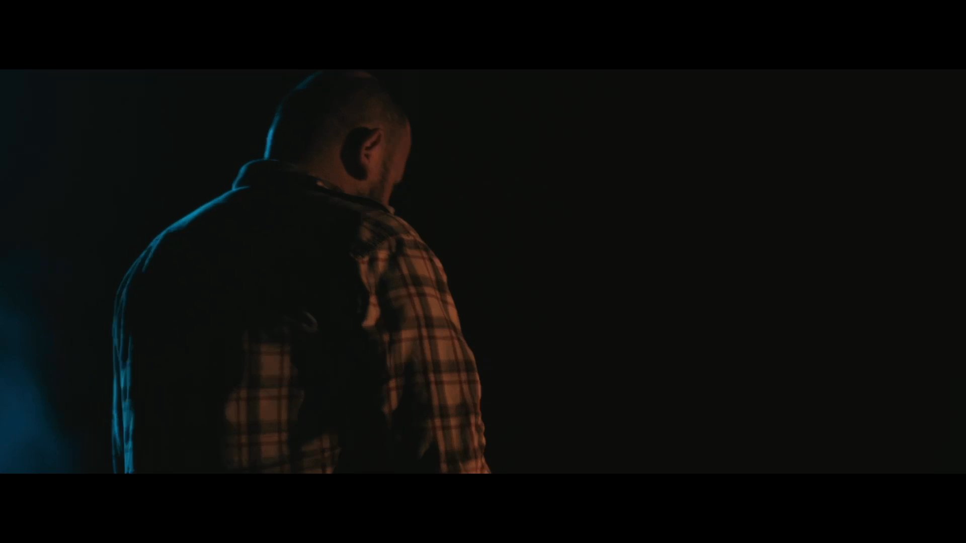 Two men discuss their plans for an early morning departure while settling down for the night beside a campfire in the darkness.
