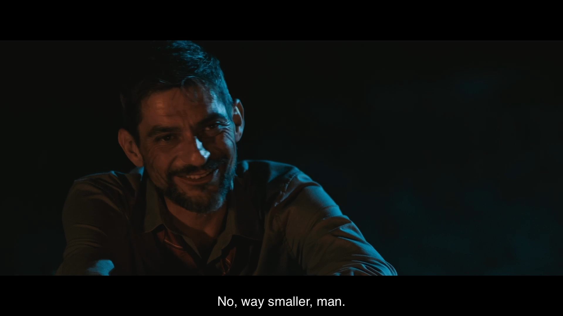 Two men engage in a nighttime conversation near a fire while discussing location and value proposition. The exchange highlights the Mr. Dollar brand and its competitive pricing.