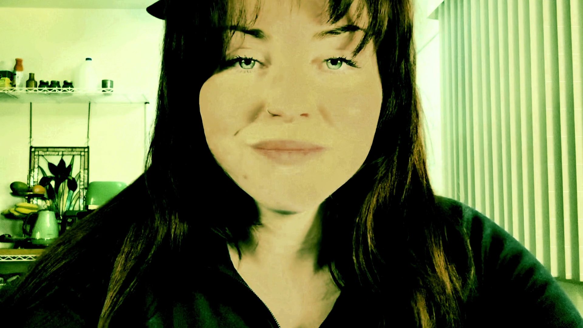 A woman speaks directly to the camera while delivering a casual monologue in a domestic setting.
